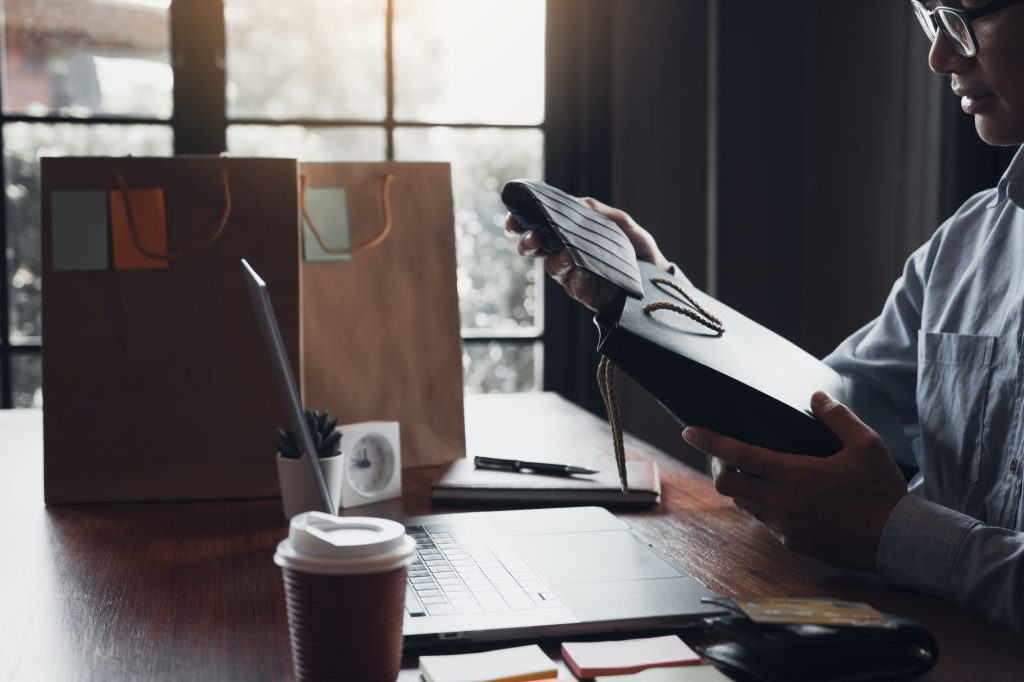 15 Gift Ideas For Your Mom & Dad. Wherever They Are This Year Man Holding A Gift Bag With A Necktie Inside Out As A Gift At The Cafe 1024x682