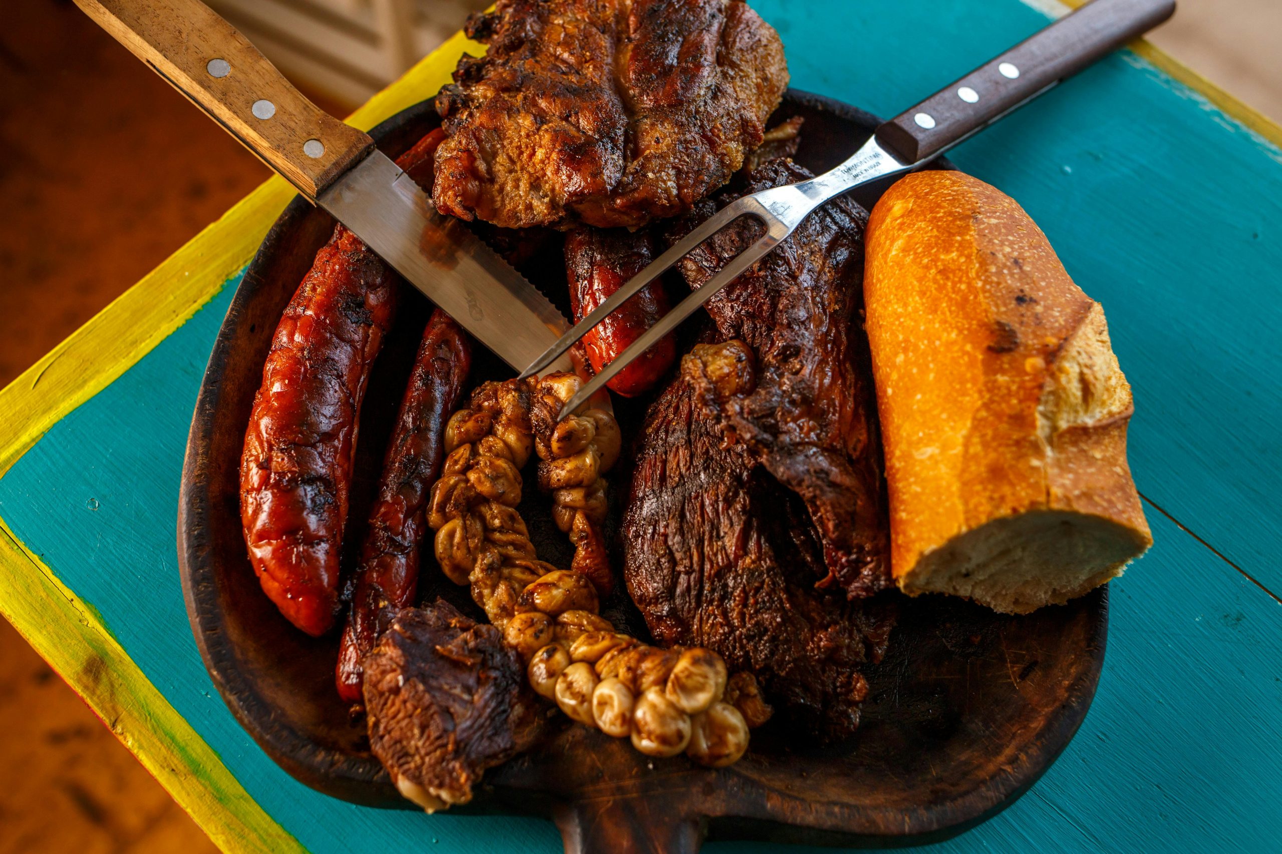 Mouth-watering grilled meat platter with sausages and bread, perfect for barbecue lovers.